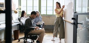 Woman using whiteboard in a small team meeting